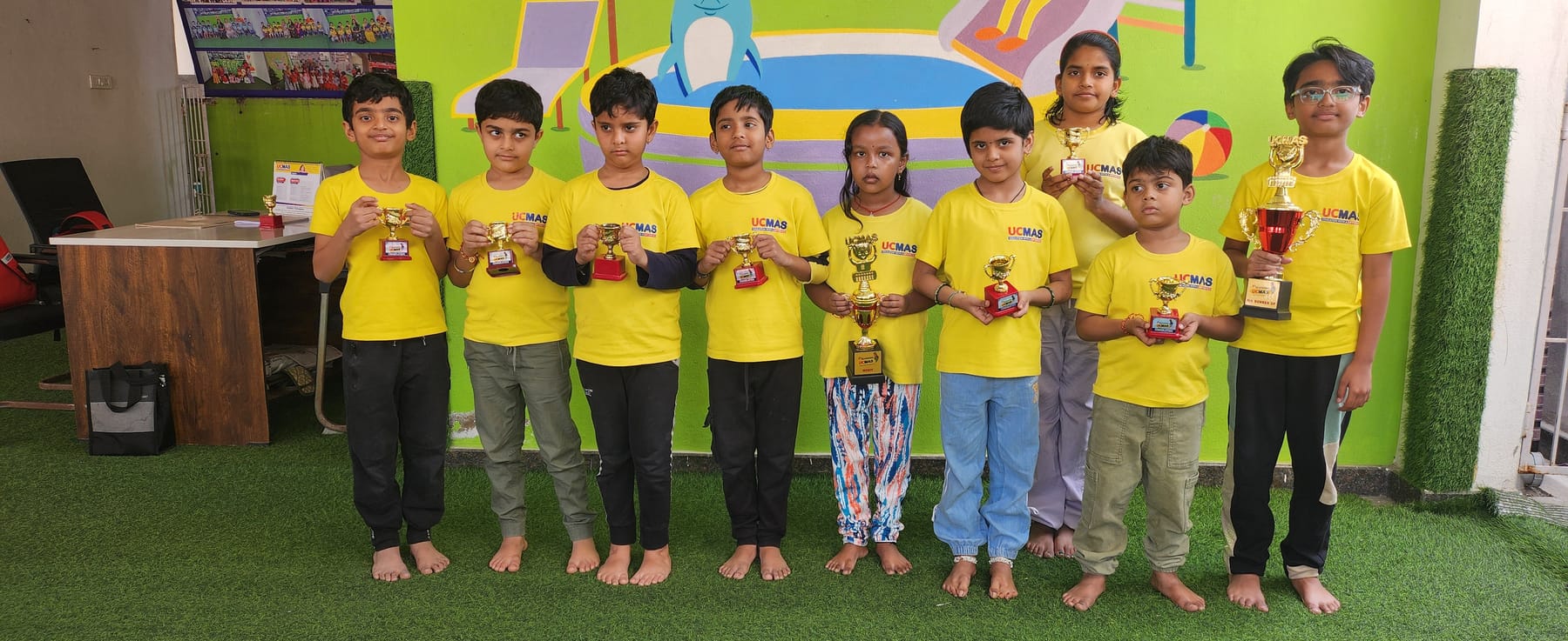 Students at UCMAS Beeramguda holding their competition trophies